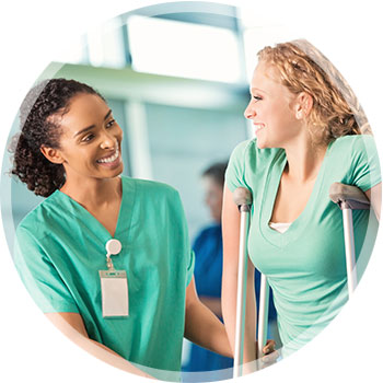 a female employee on crutches being assisted by a nurse or physical therapist